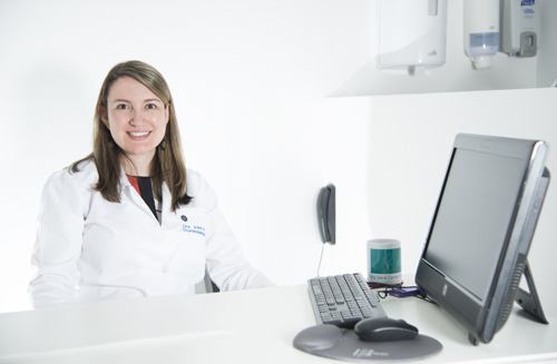 Foto de la doctora sentada en su escritorio sonriente